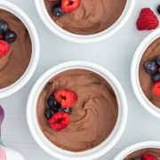 Sugar free chocolate pudding in ramekins with berries on top.